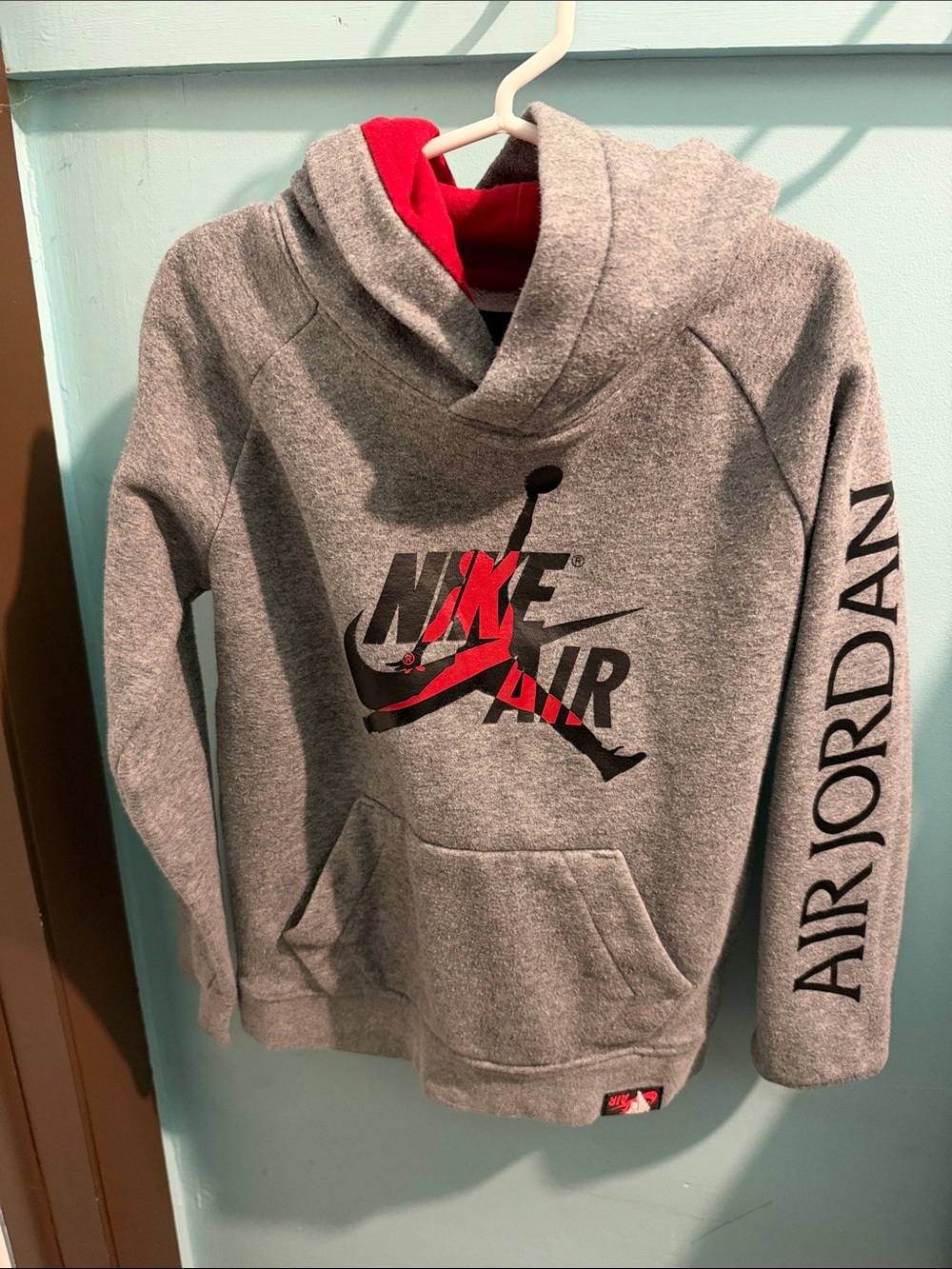 Nike Kids Gray Hoodie with Red Lining and Black Logo